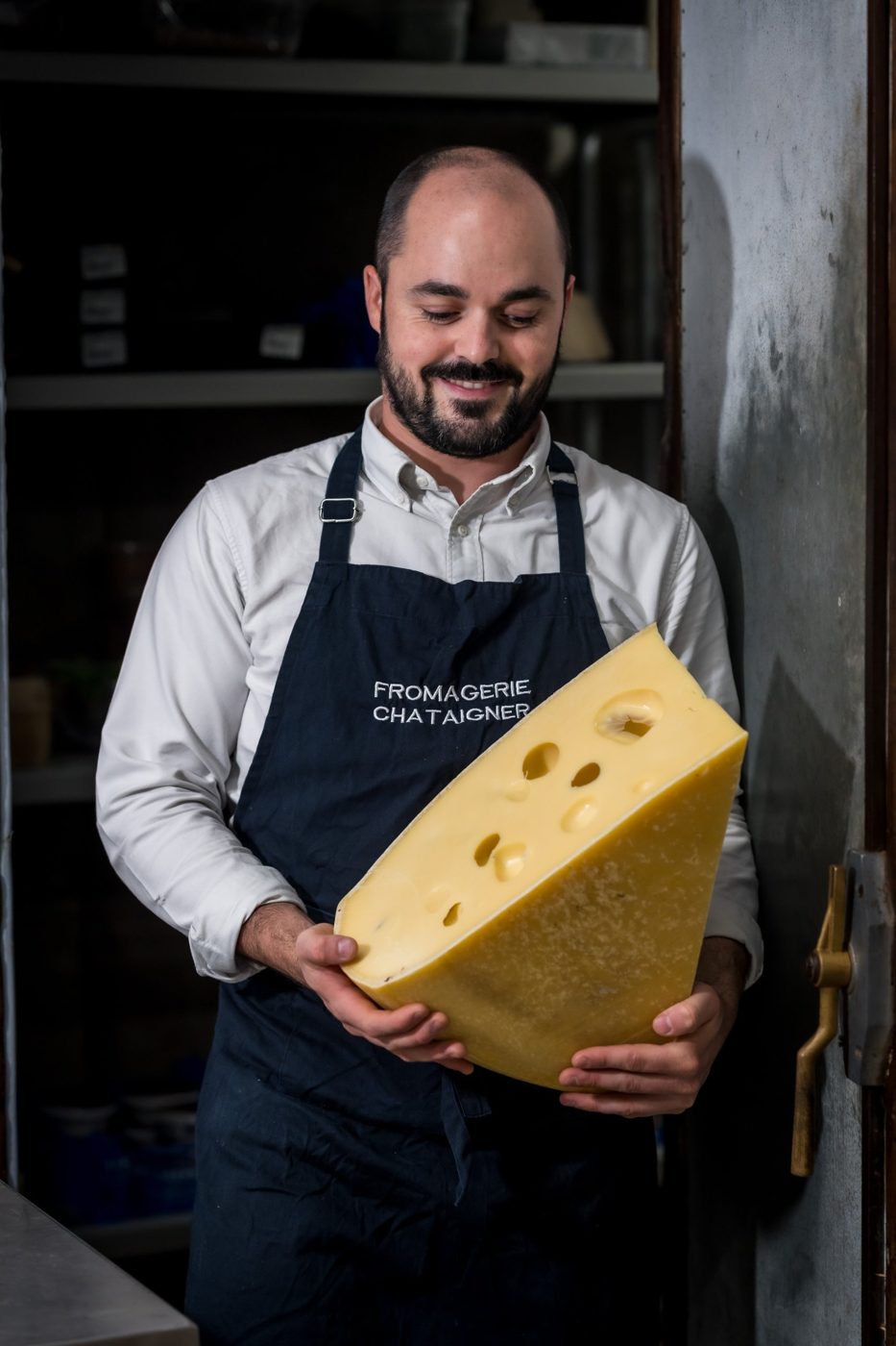 Votre fromager avec une meule de fromage